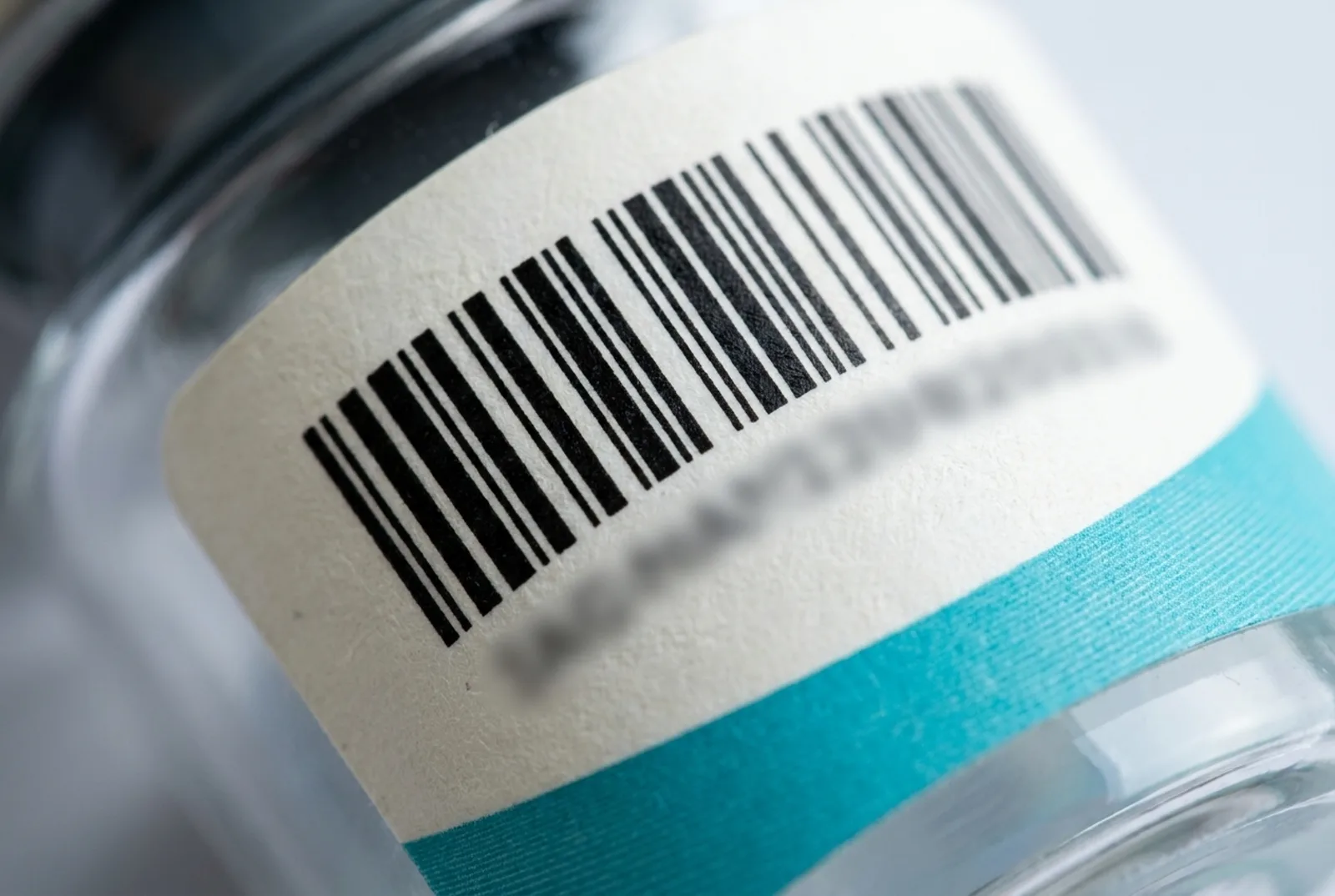 Macro-opname van de hoek van een batchlabel met barcode, lotnummer en registratieregel in monospace