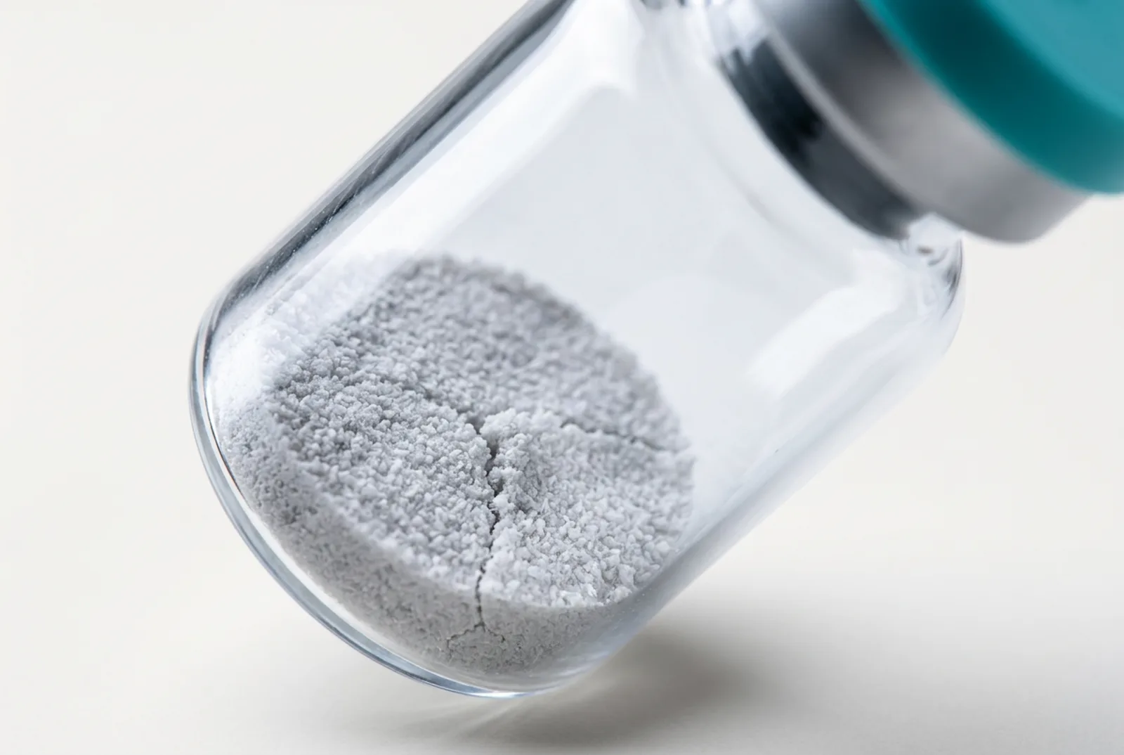 Macro-opname van kristallijne gelyofiliseerde cake in de hals van een gekantelde vial